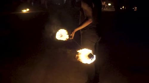 Fire dancer swinging fire balls.