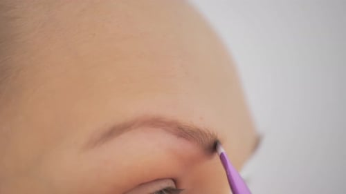 Closeup of a Woman Darkening Her Eyebrows with Makeup