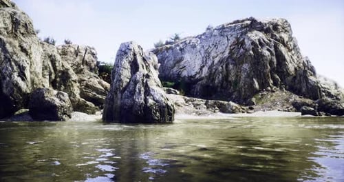 Rocky Shoreline with Calm Waters and Scenic Landscapes at Midday