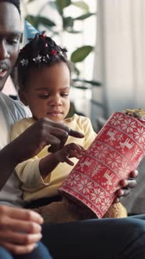 Little Girl Receives Gift with Her Father