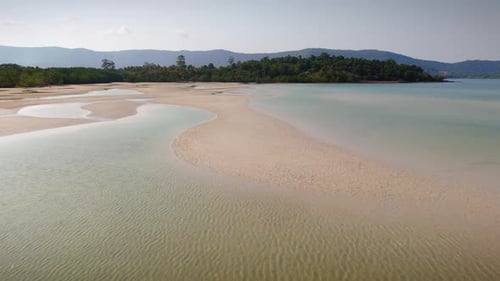 Tropical Beach Aerial With Green Trees And Silhouetted Hills On Horizon