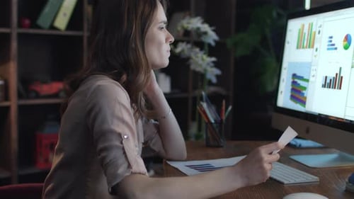 Frustrated Business Woman Working on Computer with Economic Data in Home Office
