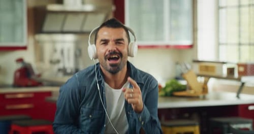 Man with Headphones Dancing in Kitchen