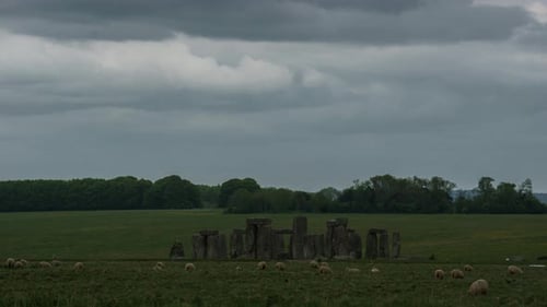 Time lapse of moving sheeps in front of prehistoric monolith circle Stonehenge, England, UK