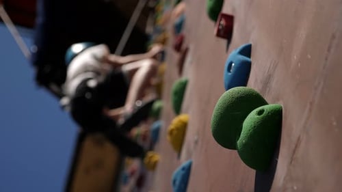 A Bottom View of a Boy Who Climbs a Climbing Wall in an Amusement Park