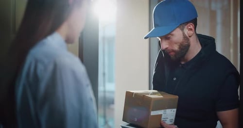 Woman Receives Package from Delivery Man at Home