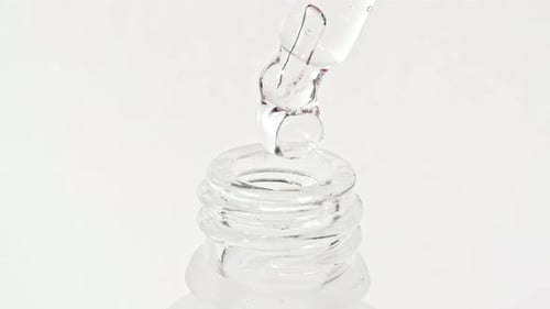 Liquid Drops from Glass Dropper into Bottle