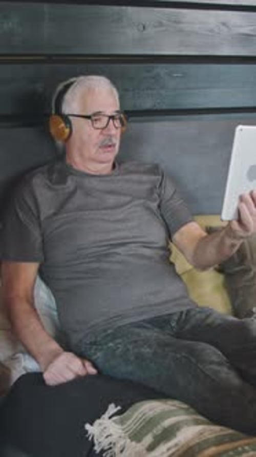 Senior Man Using Tablet to Video Call at Home