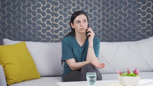 Woman Talking on Smartphone on Couch Indoors