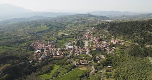 Aerial view of small town surrounded by mountains, Italy.
