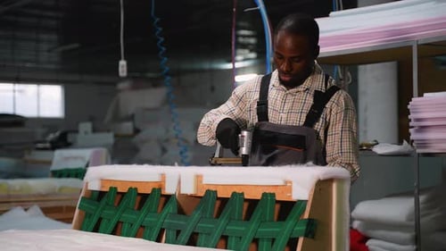 Man Using Staple Gun to Assemble Furniture