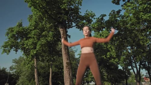 Woman Doing Jumping Jacks Outdoors in Green Park