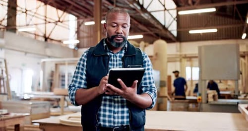 Man, carpenter and tablet at factory, scroll or check notification with furniture manufacturing