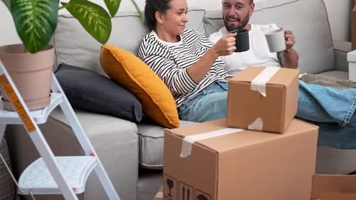 In New Home Couple Raise Coffee Cups Amid Unpacked Boxes Unboxing Exciting Journey Into New Life