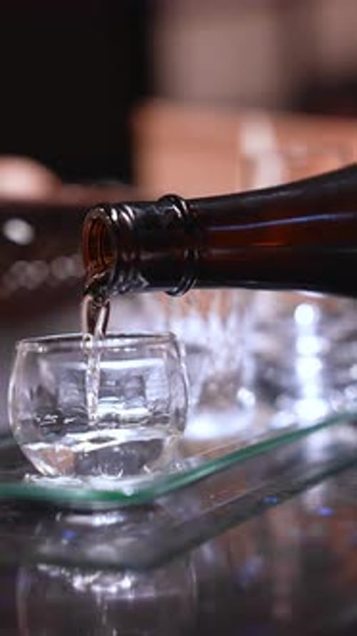 Macro Pour of Clear Liquid Into Cup in Tokyo Bar Setting