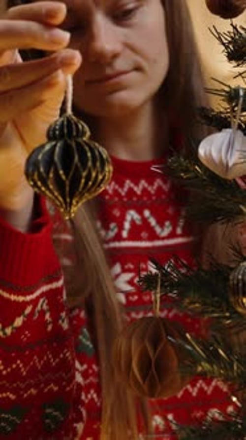 Woman Decorating Christmas Tree with Ornament