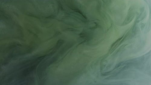 Green and White Ink Flowing in Water