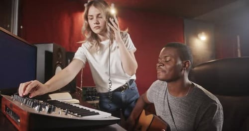 Create Music in a Music Studio Multiracial Music Band Girl in Headphones Recording and Afro American