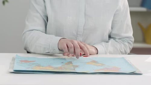 Person Places Red Pins on a World Map