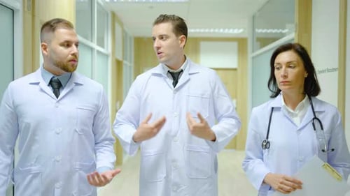 doctor man and his colleague two doctor walking hospital corridor while talking about patient health