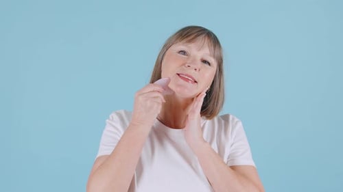 Senior Woman Using Beauty Tool for Facial Massage