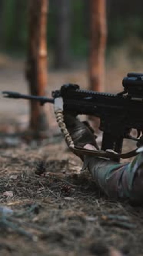 The Military Personnel is Lying on the Ground Aiming Through the Scope to Shoot