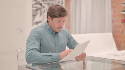 Man Reacts to Good News while Reading Document