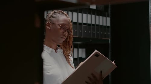 Woman Reviews Documents in Filing Room