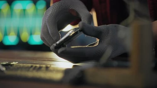 Gloved Hands Repairing a Phone