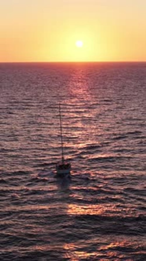 Voilier aérien vertical vers le coucher du soleil sur la mer Méditerranée, scène idyllique