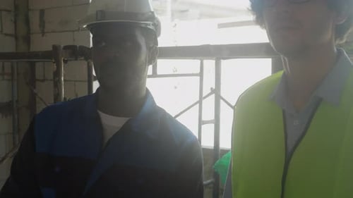 Workers Discuss Building Construction in Daytime Sunlight