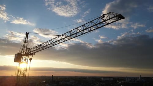 Construction Crane Silhouette Descending at Sunset Aerial View