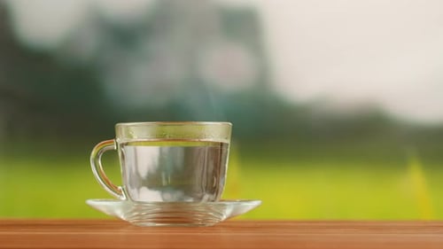 Hot Water for the Red Fruit Tea in Glass Cup on a Wooden Table