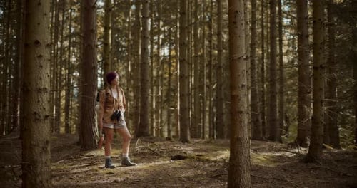 Young Woman Looking Around Forest