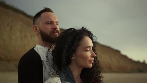 Romantic multiethnic couple embrace enjoying peaceful sunset beach vacation