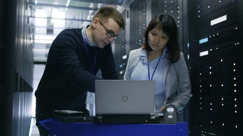 Technicians Working on Laptop in Data Center