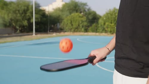 Pickleball Player Bouncing Ball on Paddle Outdoors