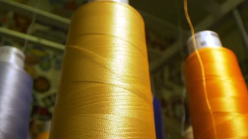 Golden Thread Uncoiling From Spool By Machine Tool in Shop
