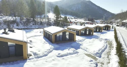 Group of Houses Stands in Valley Surrounded By Mountains