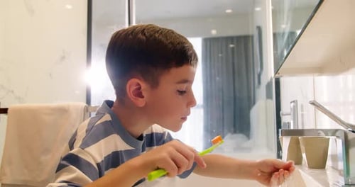 Boy Brushing Teeth in Modern Bathroom