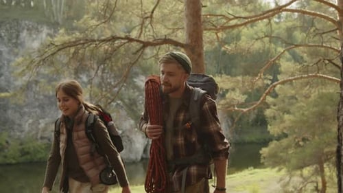 Two Travelers Going Together through Woods during Summer Hike