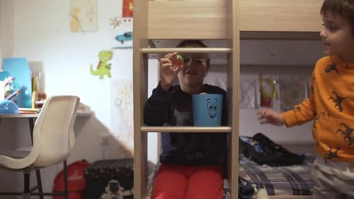 Two Children Playing in a Bedroom with a Bunk Bed