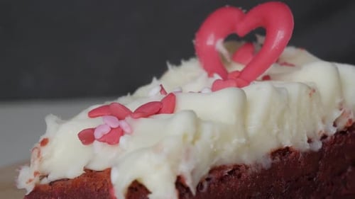 Close-up of red velvet brownie with creamy frosting and heart decoration for Valentine’s Day