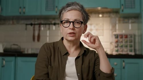 Woman Speaking and Gesturing Indoors in Kitchen