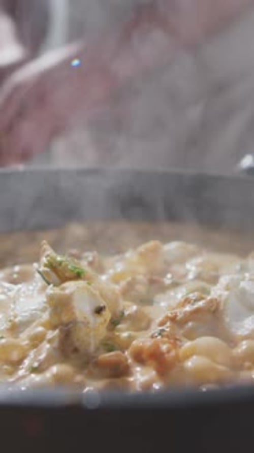 Close-up of Unrecognizable Chef Adding Fresh Parsley to Creamy Chicken Stew