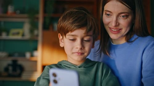 Mother and Son Using Smartphone Indoors