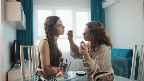 Freunde üben Make-up, lernen Make-up mit Freunden und teilen ihre Make-up-Fähigkeiten am Tisch, lässiges Make-up