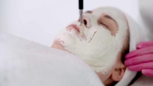 Spa and Cosmetology Beauty Treatment Apply Facial Mask for Mature Woman Beauty Salon Close Up