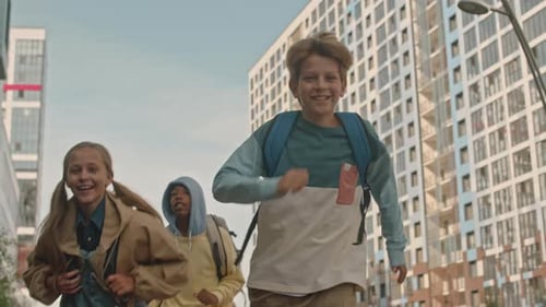 Multiracial Schoolkids Running along Street in Summer