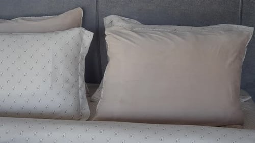 Neatly Made Bed with Pillows and Decorative Bedding